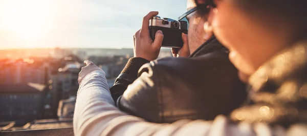 Couple taking pictures on rooftop — Stock Photo, Image