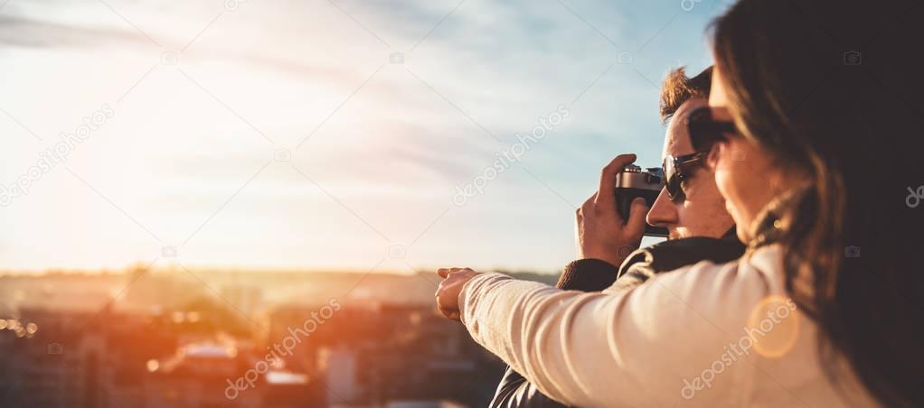 Couple taking pictures on rooftop