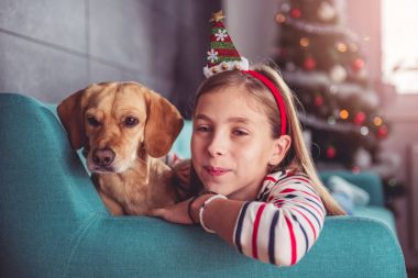 Kanepenin üzerinde poz köpek ile küçük kız  