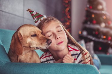 Noel Baba şapkası ve küçük sarı köpek kafa giyen kız