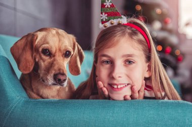 Kanepenin üzerinde poz köpek ile küçük kız