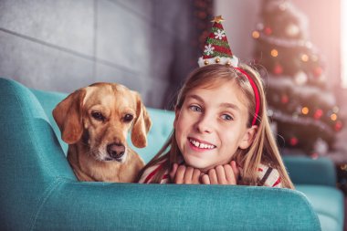 Kanepenin üzerinde poz köpek ile küçük kız