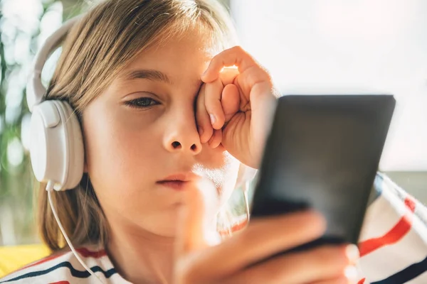 Tired Little Girl Headphones Using Smart Phone Rubbing Eyes — Stock Photo, Image