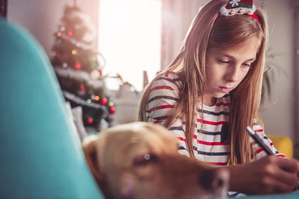 Chica con perro escritura lista de deseos — Foto de Stock