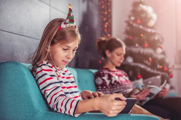 Hija Madre Relajándose Sofá Azul Frente Árbol Navidad Usando Teléfono —  Fotos de Stock