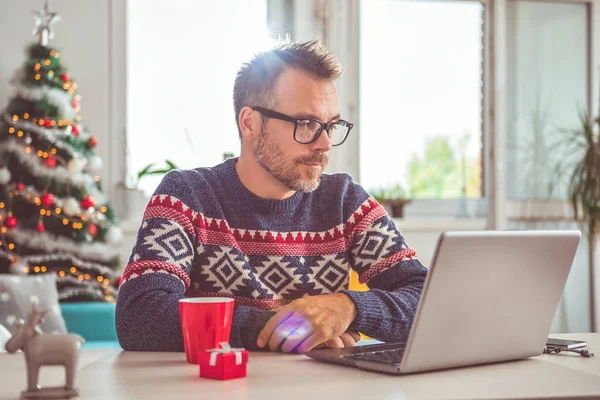 Man Wearing Blue Sweater Eyeglasses Using Laptop Home Office Christmas — Stock Photo, Image