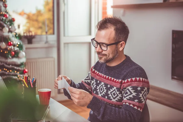 Man opening Christmas letter