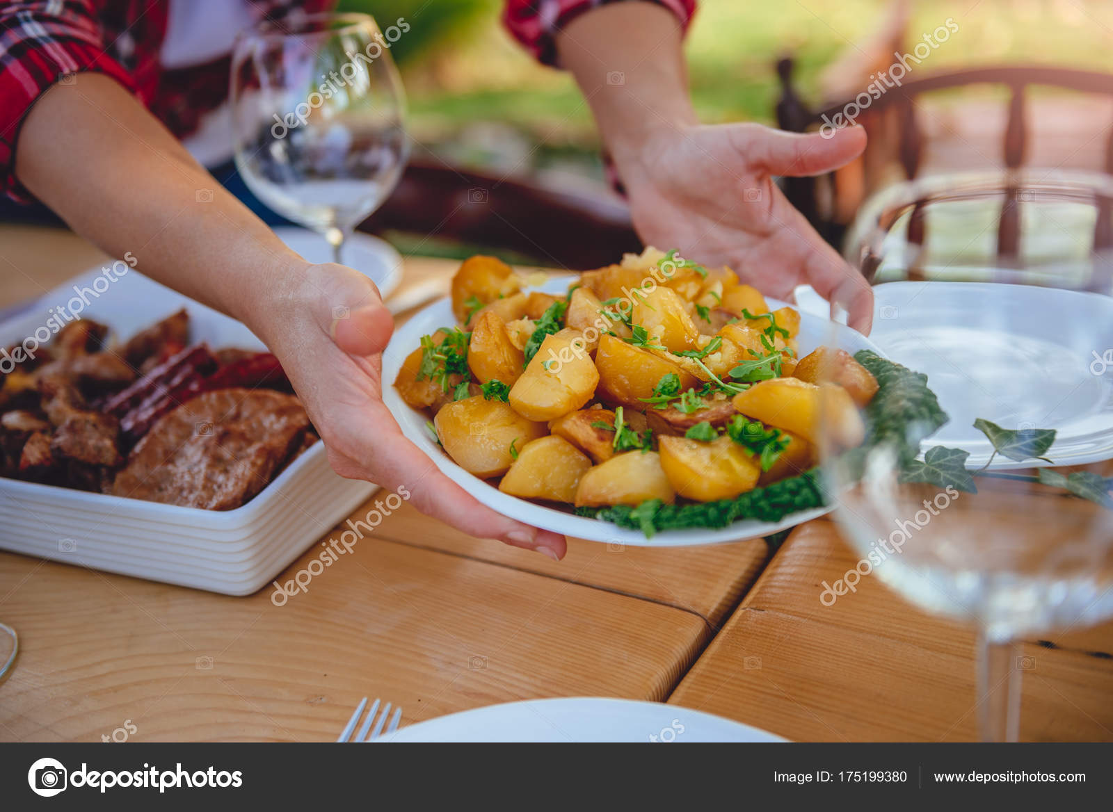 Woman Serving Roasted Potatoes Dining Table Backyard Patio Stock Woman Serving Roasted Potatoes Dining Table Backyard Patio Stock