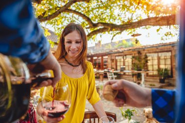 Adam kırmızı şarap sürahi gelen kadın cam arka bahçe veranda, içine dökülen 