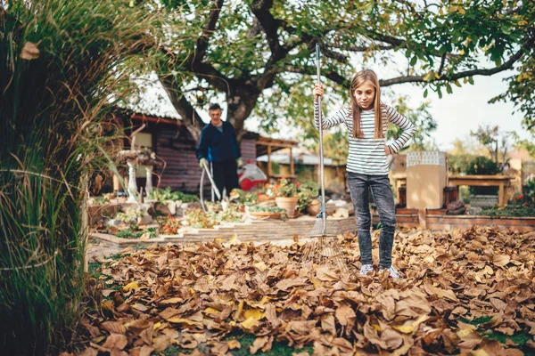 Dívka Hrabání Podzimní Listí Zahradě — Stock fotografie