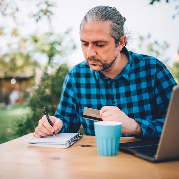 Men sitting in the backyard patio and writing down notes — Stock Photo, Image