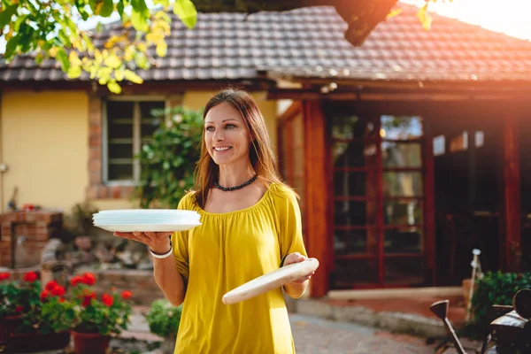 Happy woman holding dishes — Stock Photo, Image