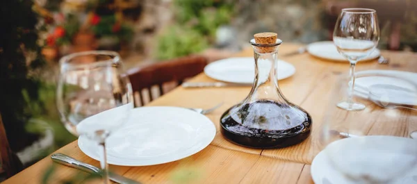 Wine decanter and glasses on dining table in backyard patio