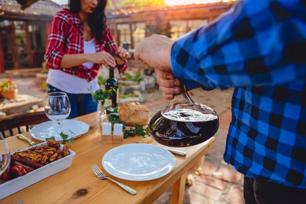 Hombre Sosteniendo Decantador Vino Por Encima Mesa Comedor Patio Trasero — Foto de Stock