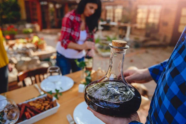 Hombre Sosteniendo Decantador Vino Por Encima Mesa Comedor Patio Trasero — Foto de Stock