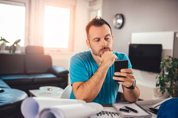 Muž Modré Košili Pomocí Chytrého Telefonu Uvažuje Domácí Kancelář — Stock fotografie