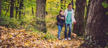 Anne ve kızı köpek ile bir ormandaki hiking