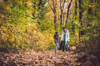 Anne ve kızı köpek ile bir ormandaki hiking
