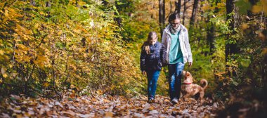 Anne ve kızı köpek ile bir ormandaki hiking