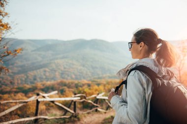 Manzarayı dağın zirvesinde günbatımı sırasında kadın