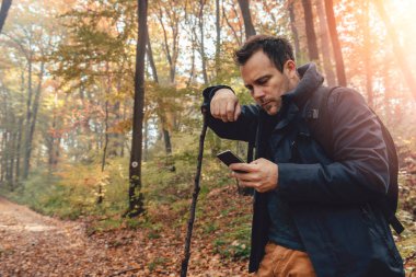 Sonbahar renkli ormanda yürüyüş ve istimal telefon adam