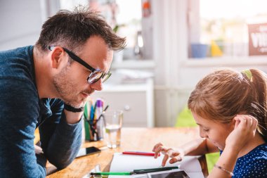 Liseli kız ev ödevi, masanın ayakta ve onu izlerken babası bitirmek için tablet kullanma
