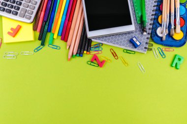 Yeşil arka planda okul malzemeleri