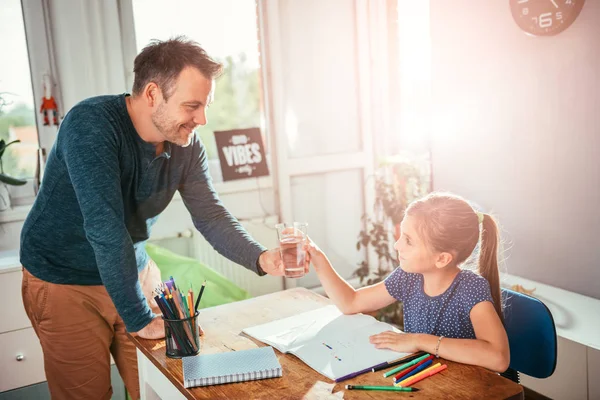 Padre Dando Vaso Agua Hija Mientras Ella Está Haciendo Tarea — Foto de Stock