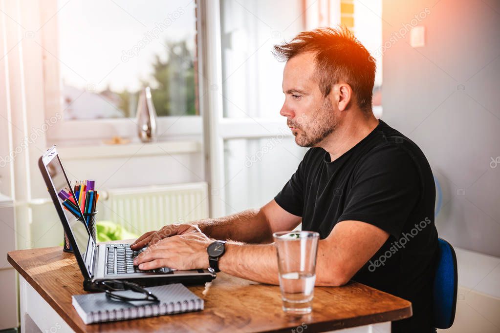 Man in black shirt working on laptop