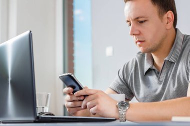 dizüstü bilgisayar, mesaj sms ofiste çalışan iş adamı