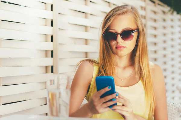 若い女性夏のカフェに座っていると スマート フォンを使用して — ストック写真