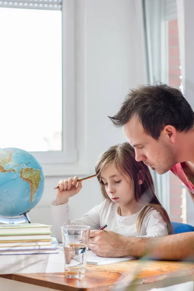 close-up of Father Helping Daughter With Homework at home
