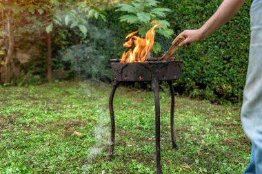 Yakacak odun Barbekü koyarak bir çim adam