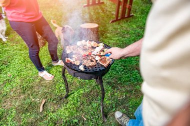 Adam aile akşam yemeği için tavuk meyilli olarak Barbekü yemek