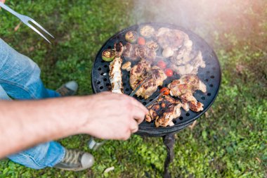 Adam aile akşam yemeği için tavuk meyilli olarak Barbekü yemek