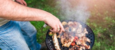 Adam aile akşam yemeği için tavuk meyilli olarak Barbekü yemek