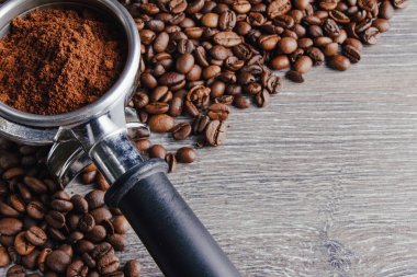 Portafilter ve kahve çekirdekleri ahşap arka plan üzerinde yakın çekim