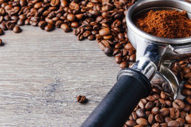 Portafilter ve kahve çekirdekleri ahşap arka plan üzerinde yakın çekim