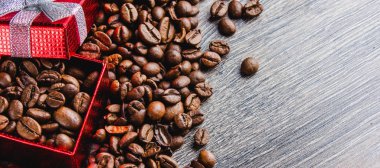 Kahve çekirdekleri kırmızı hediye kutusu üzerinde ahşap arka planda Close-Up