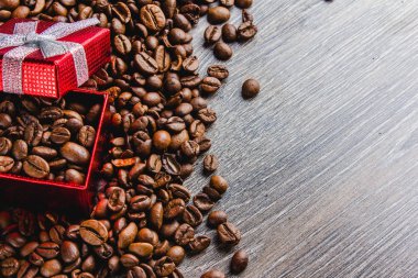 Kahve çekirdekleri kırmızı hediye kutusu üzerinde ahşap arka planda Close-Up