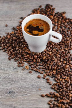 Beyaz fincan kahve fasulye ahşap arka plan ile yakın çekim