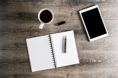 Defter, kalem ve ahşap masa üzerinde dijital tablet kahve