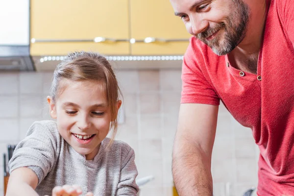 Father and daughter making dough