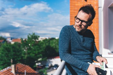 Euro faturaları cüzdan dışarı alarak mavi tişörtlü hipster adam.