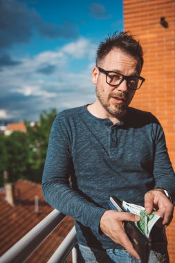 Euro faturaları cüzdan dışarı alarak mavi tişörtlü hipster adam.
