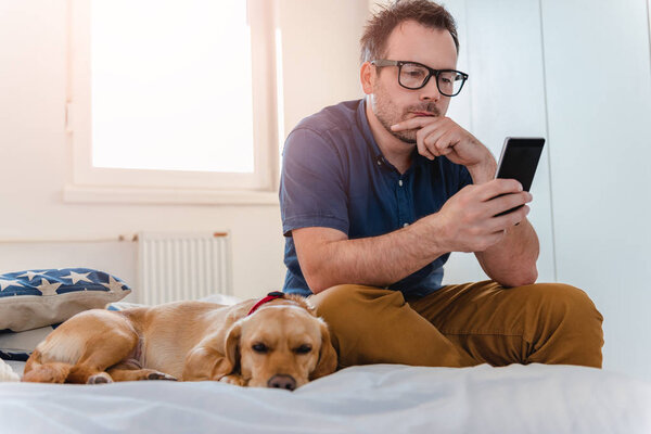 Man Glasses Blue Shirt Sitting Bed Dog Using Smart Phone — Stock Photo, Image