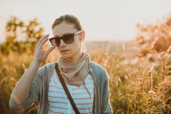 Kadın Bir Çayır Gün Batımı Sırasında Poz Güneş Gözlüğü — Stok fotoğraf