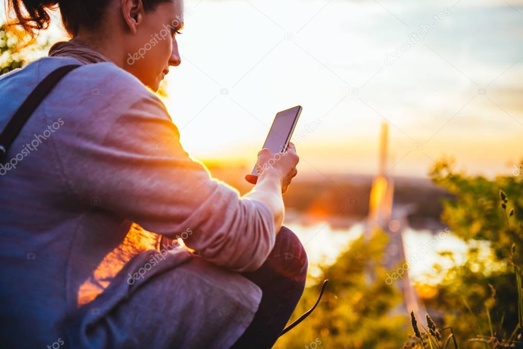 Woman using smart phone during sunset