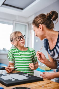 Resim öğretmeni sanat dersi sırasında resim ile bir öğrenci yardım