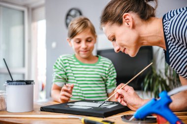 Resim öğretmeni sanat dersi sırasında resim ile bir öğrenci yardım